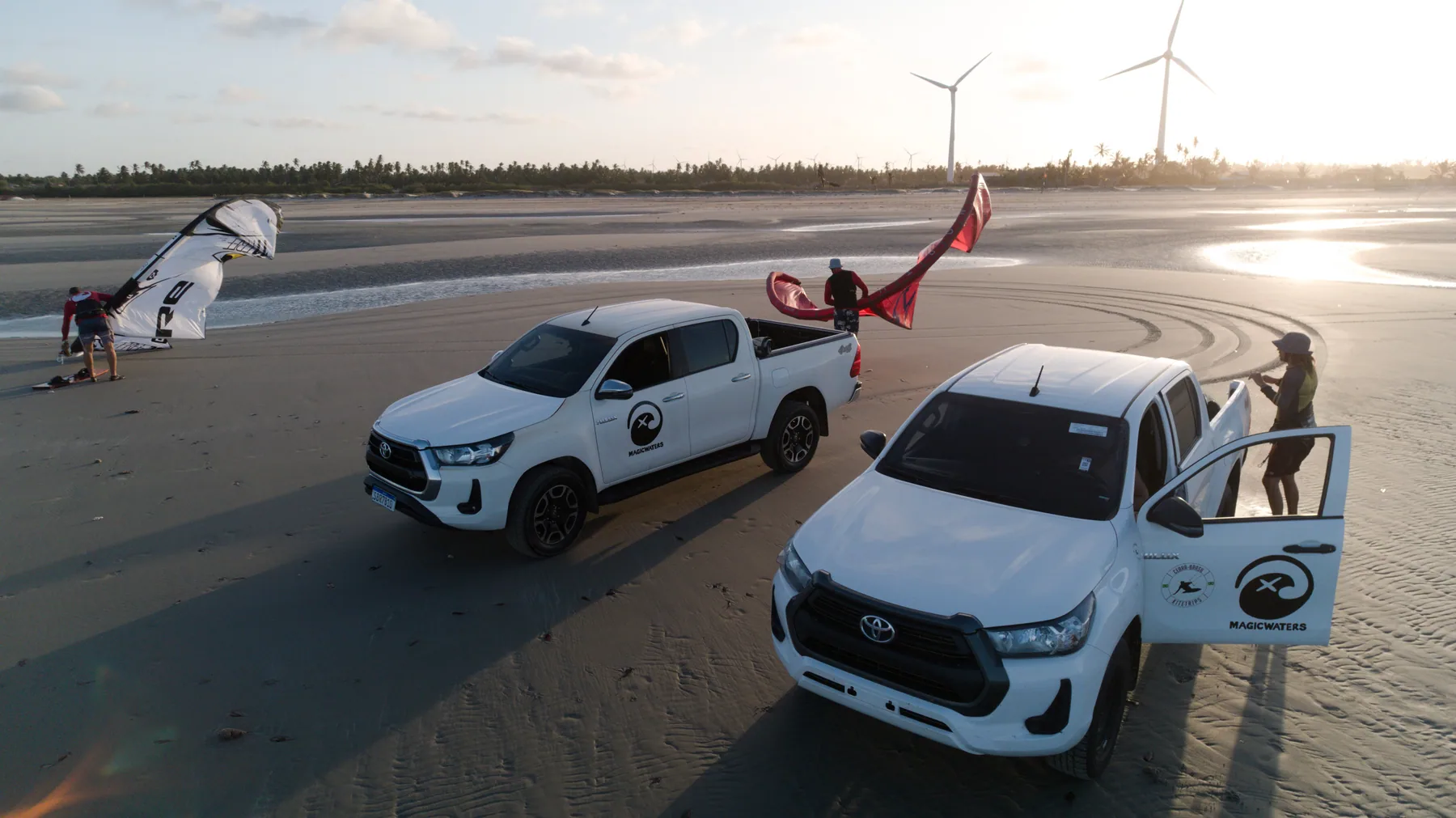 Pick-ups und Kite-Material am weiten Strand in Brasilien