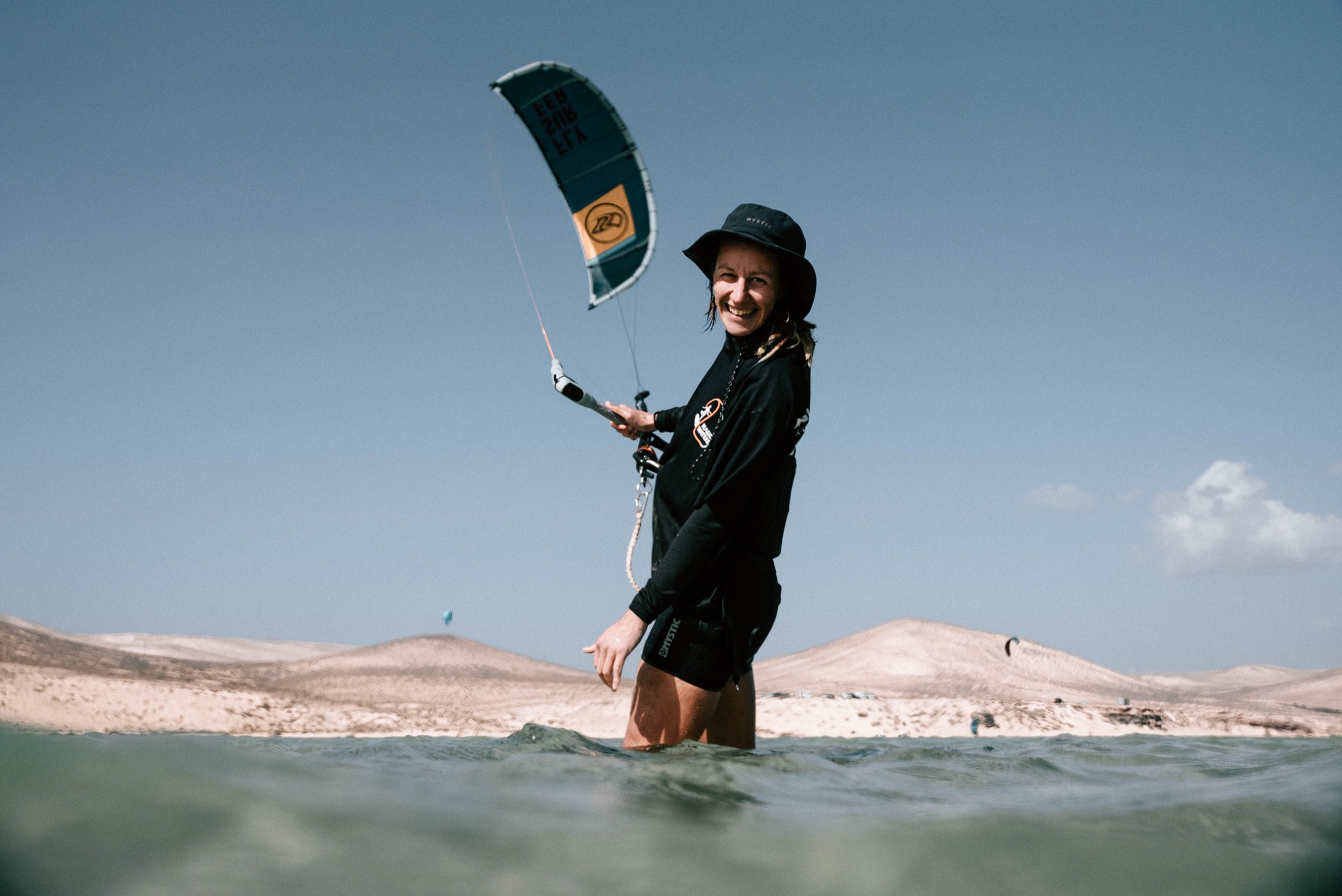 Kitesurfer fährt durch spritzendes Wasser